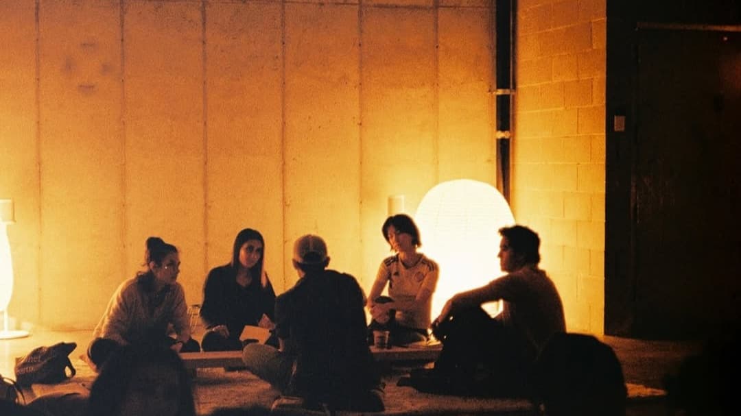 Orange-toned salon gathering — ZNTHWRLD community mission for emerging artists